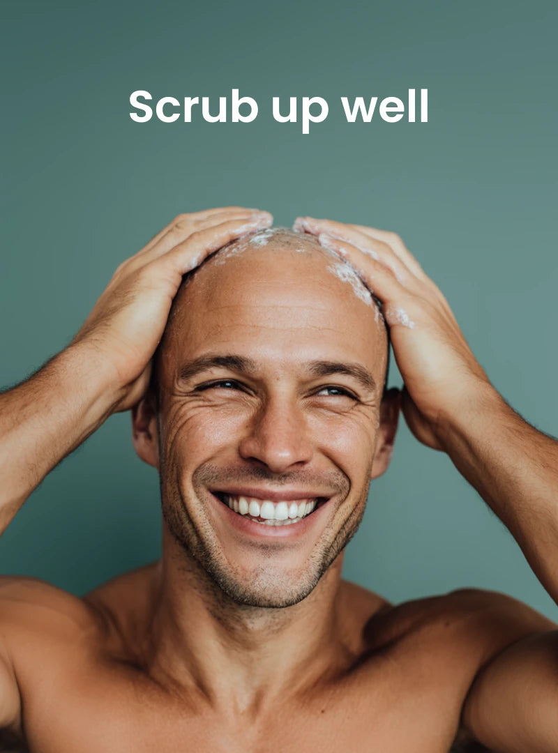 Man washing his hair with a text overlay 'Scrub up well' on a solid background