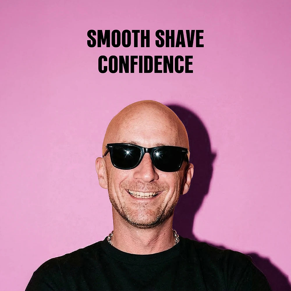 A smiling bald man wearing black sunglasses and a black shirt, set against a solid pink background with the text 'SMOOTH SHAVE CONFIDENCE' above him.